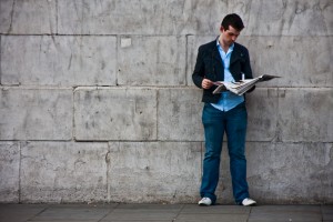 Reading A Newspaper By A Wall
